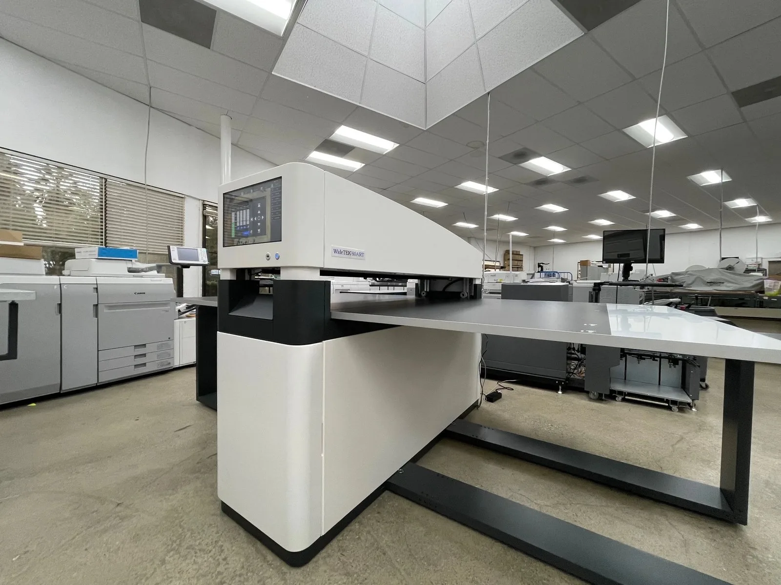 Production floor at Super Printers in Laguna Hills, showing the WideTEK 60ART-800 scanner alongside commercial printing equipment